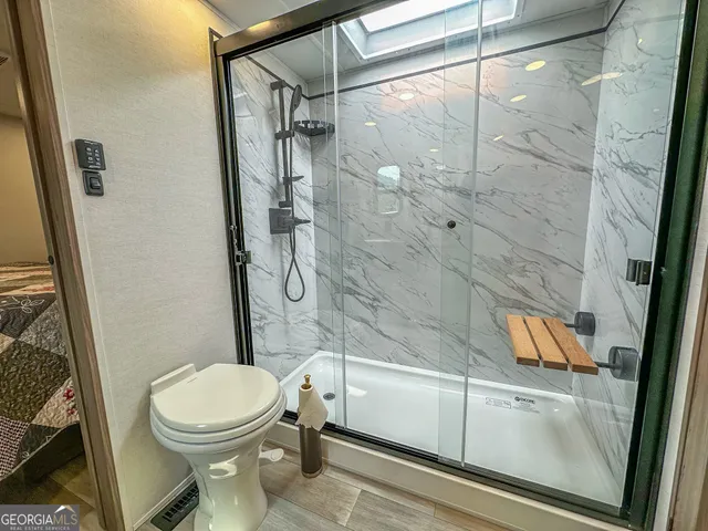 a bathroom with a toilet and a shower