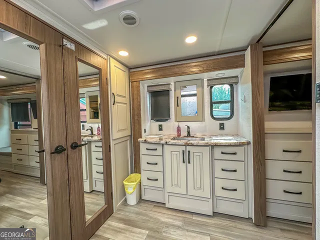 a bed sitting in a bedroom and view of bathroom