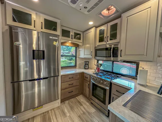 a kitchen with stainless steel appliances granite countertop a sink and a refrigerator