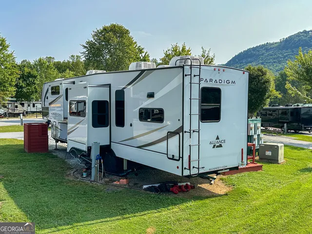 a view of a white house with a big yard and a large tree