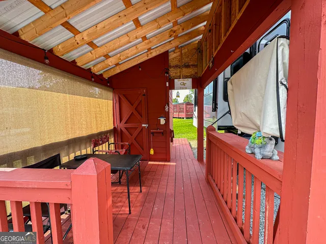 a balcony with chairs and wooden fence