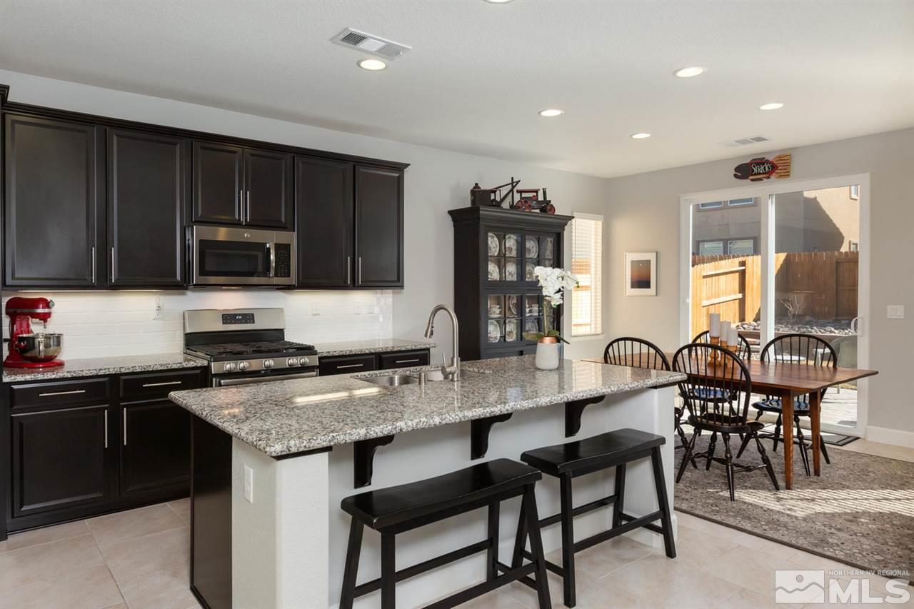 1830 Cascade Stable Lane Reno, NV 89521 - Photo 5 of 25 a kitchen with granite countertop a stove a sink a dining table and chairs