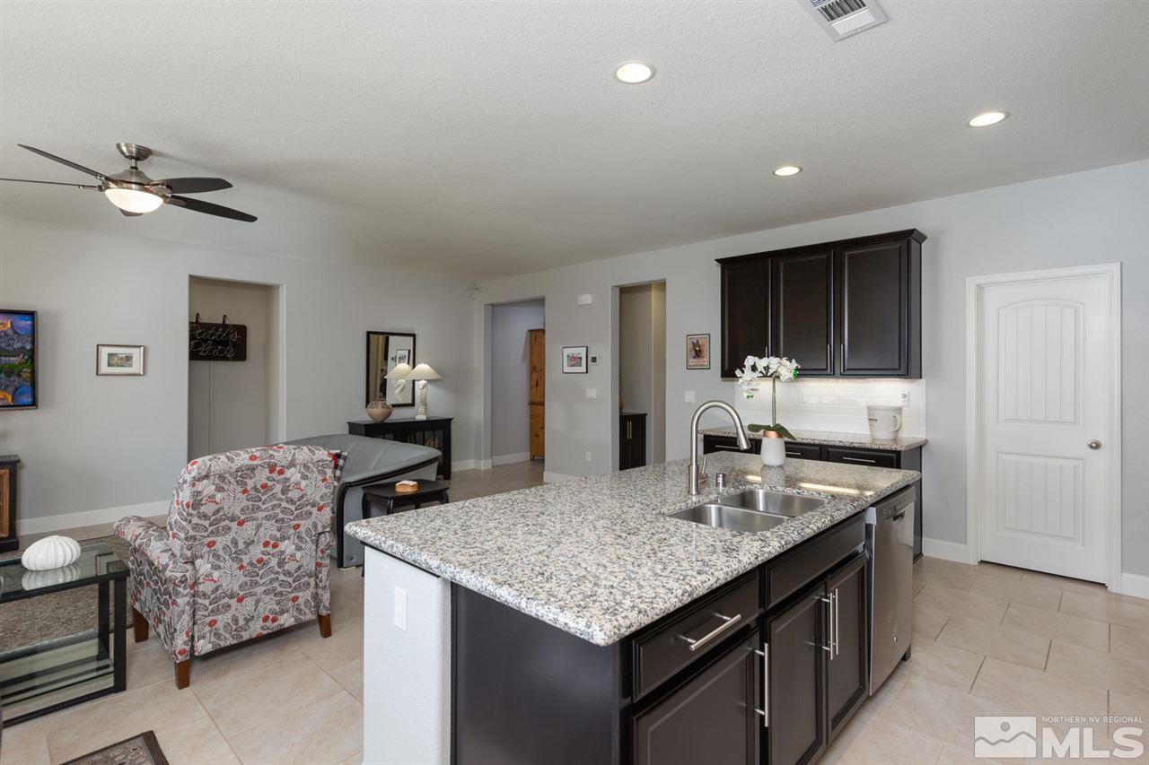 1830 Cascade Stable Lane Reno, NV 89521 - Photo 7 of 25 a kitchen with granite countertop cabinets a sink dishwasher and a refrigerator with wooden floor