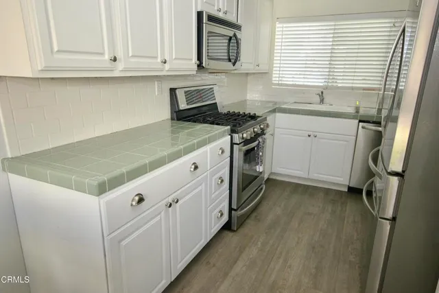 a kitchen with granite countertop a sink stove and cabinets