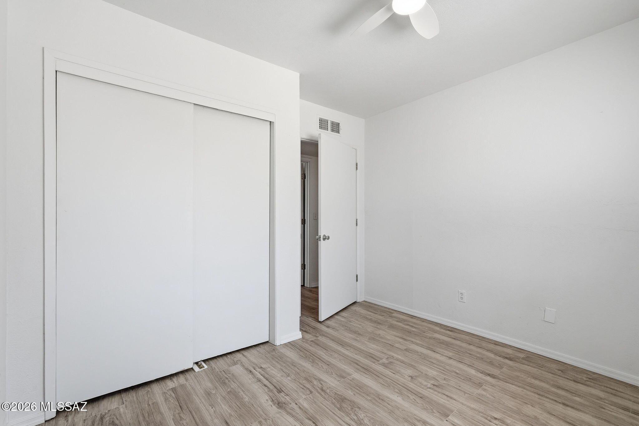 136 West Elvira Road Tucson, AZ 85756 - Photo 20 of 27 a view of an empty room with wooden floor and a ceiling fan