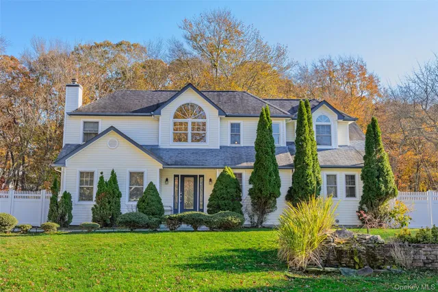 a front view of a house with a yard and trees
