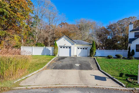 a view of a house with a yard and large tree