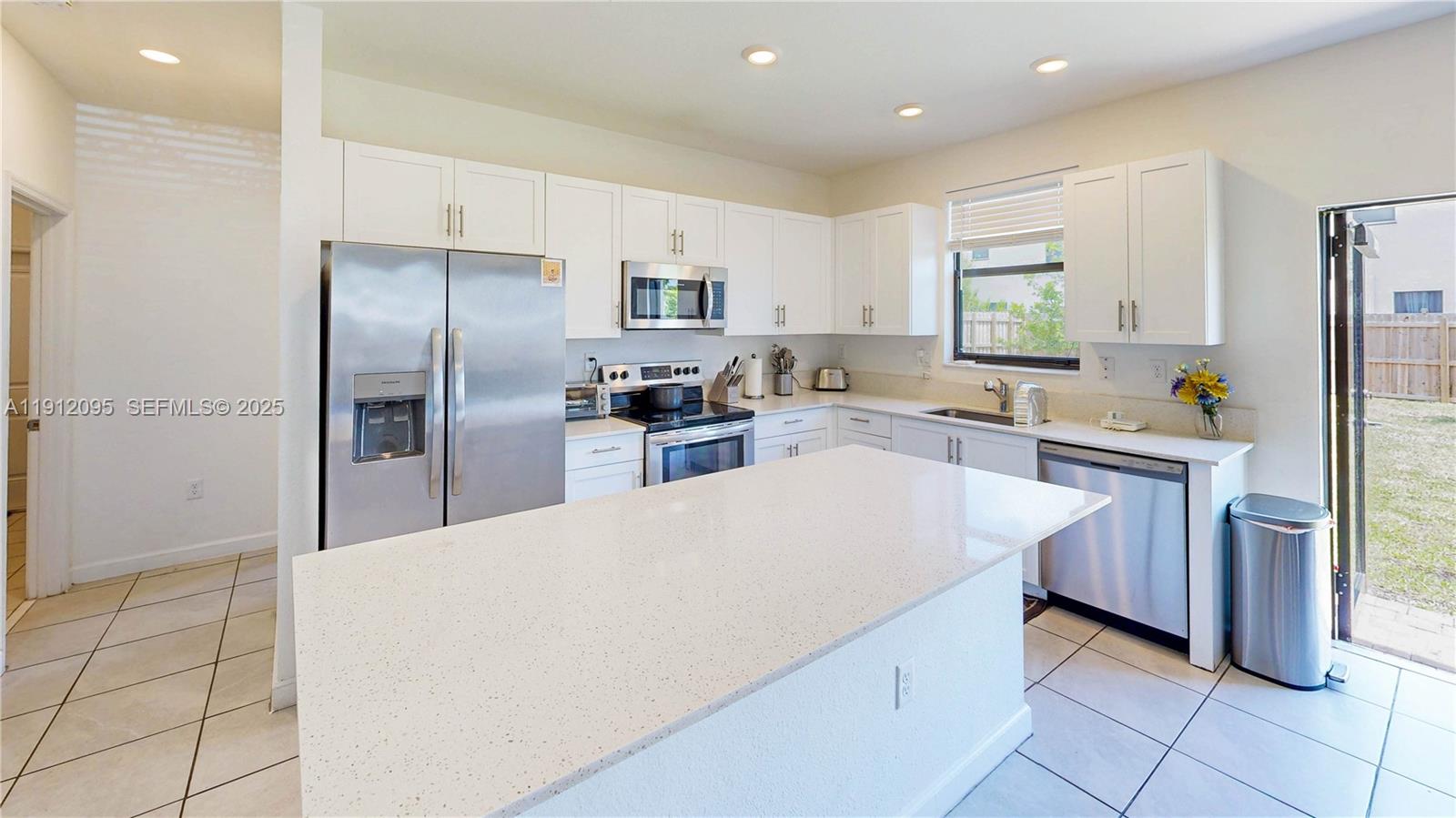 11964 Southwest 244th Street Homestead, FL 33032 - Photo 10 of 62 a large kitchen with kitchen island a sink stainless steel appliances and cabinets