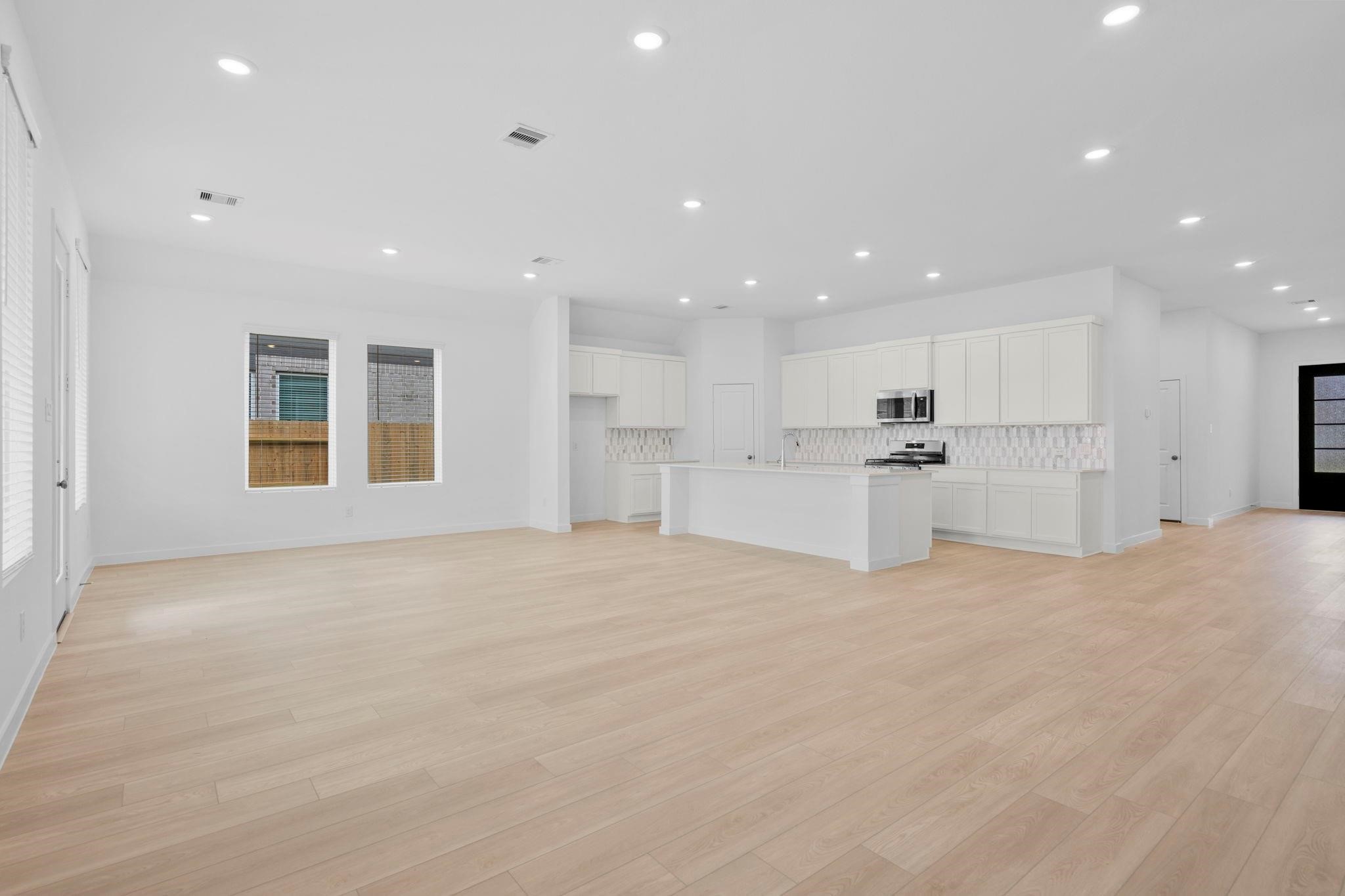 2716 Pine Bluff Drive Rosenberg, TX 77469 - Photo 5 of 32 a view of an empty room with kitchen island white cabinetry and refrigerator