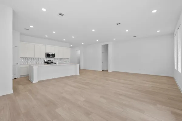 a view of kitchen with kitchen island a sink and a stove top oven