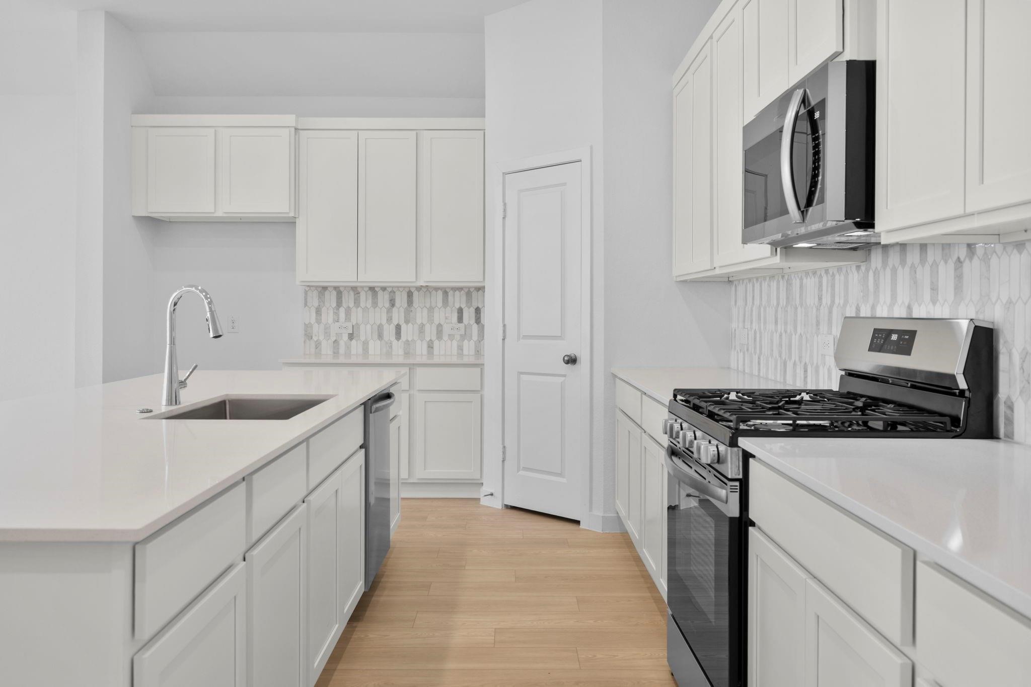 2716 Pine Bluff Drive Rosenberg, TX 77469 - Photo 8 of 32 a kitchen with white cabinets and white appliances