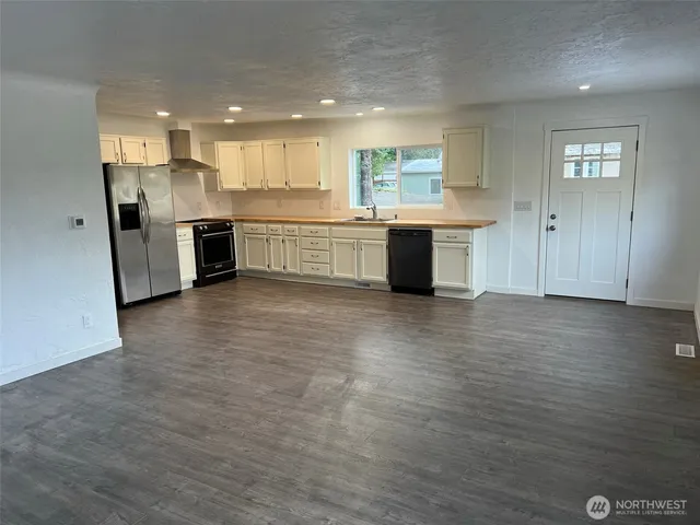 a large kitchen with stainless steel appliances granite countertop a large counter top a sink and a stove