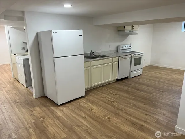 a kitchen with a refrigerator sink and cabinets