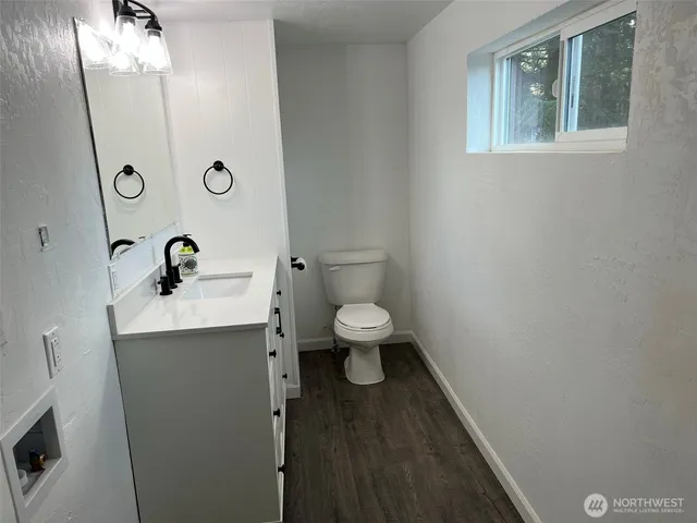 a bathroom with a toilet a sink and mirror