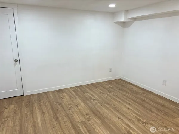 a view of empty room with wooden floor