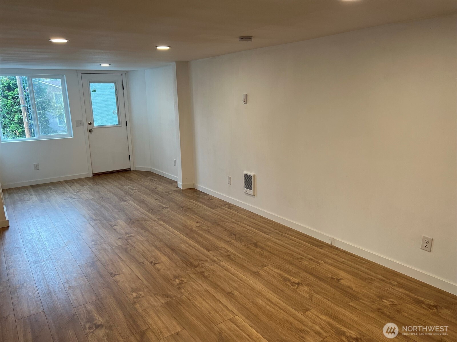 1663 Harrison Avenue Southeast Port Orchard, WA 98366 - Photo 7 of 30 an empty room with wooden floor and windows