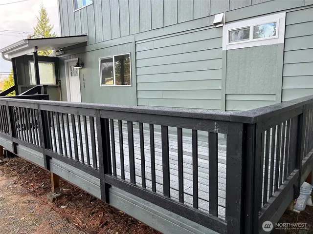 a view of a house with a small yard and wooden floor and fence