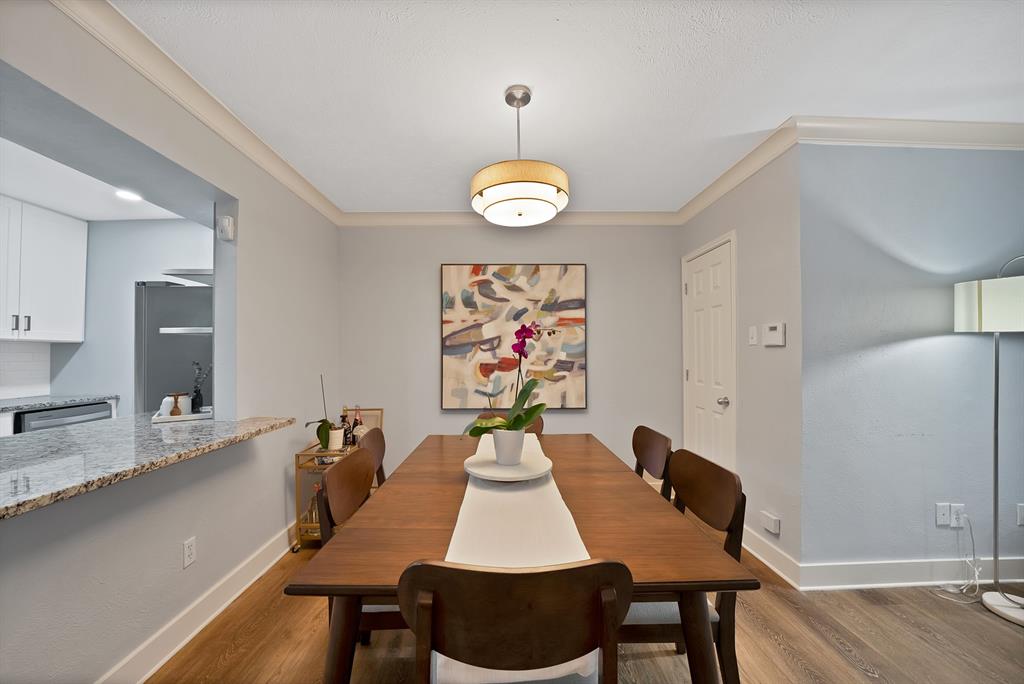 7738 Meadow Road, Unit 109 Dallas, TX 75230 - Photo 11 of 35 a view of a dining room with furniture wooden floor and chandelier