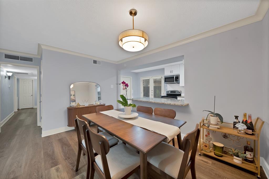 7738 Meadow Road, Unit 109 Dallas, TX 75230 - Photo 13 of 35 a view of a dining room with furniture and wooden floor