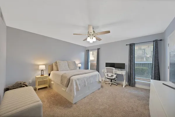 a spacious bedroom with a bed and a chandelier