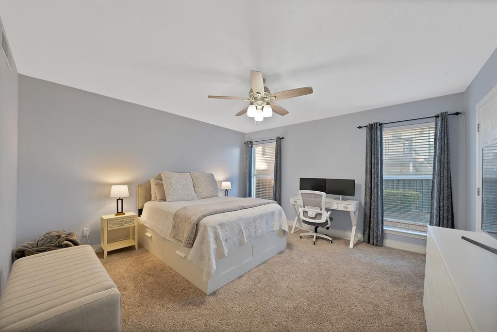 7738 Meadow Road, Unit 109 Dallas, TX 75230 - Photo 18 of 35 a spacious bedroom with a bed and a chandelier
