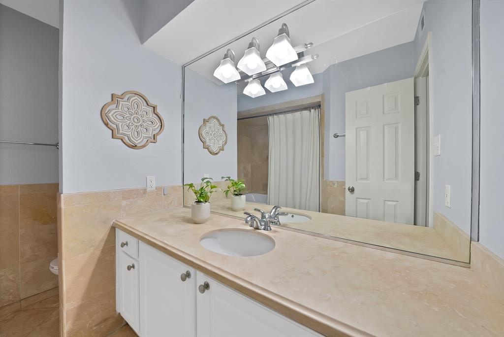 7738 Meadow Road, Unit 109 Dallas, TX 75230 - Photo 25 of 35 a bathroom with a sink vanity and a mirror