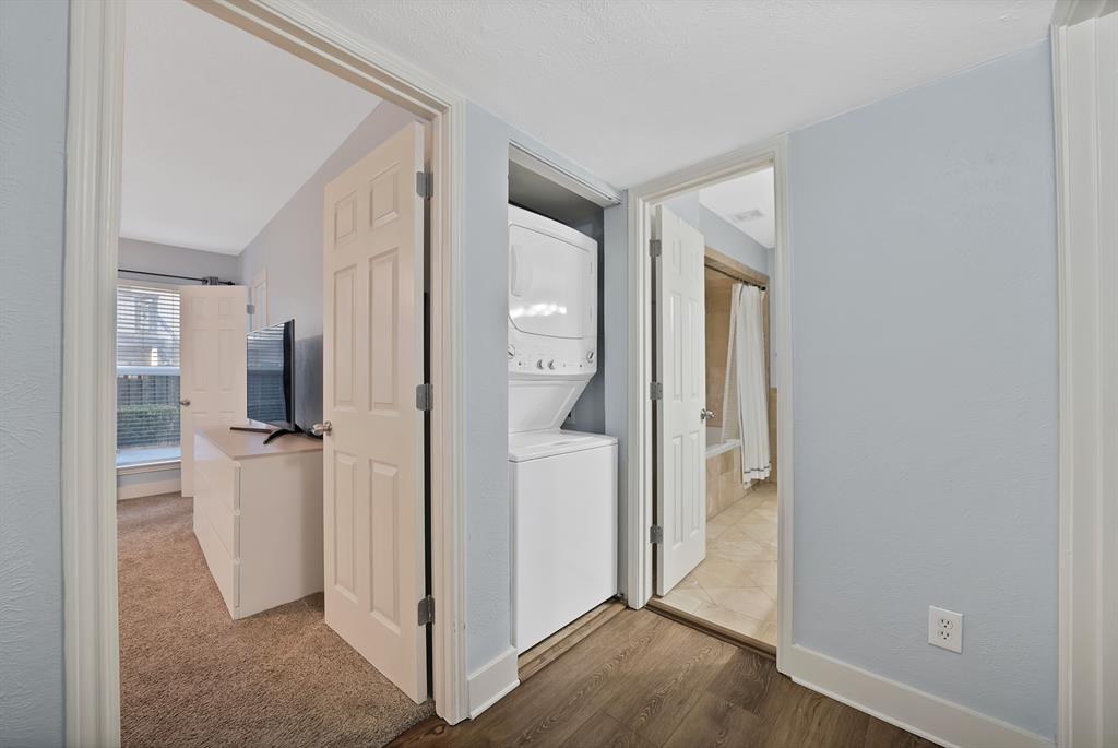 7738 Meadow Road, Unit 109 Dallas, TX 75230 - Photo 27 of 35 a view of a hallway with bathroom and wooden floor