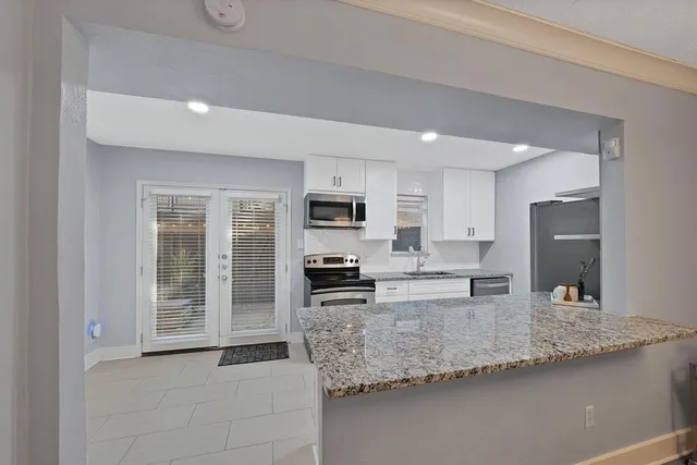 a kitchen with stainless steel appliances granite countertop a sink refrigerator and stove