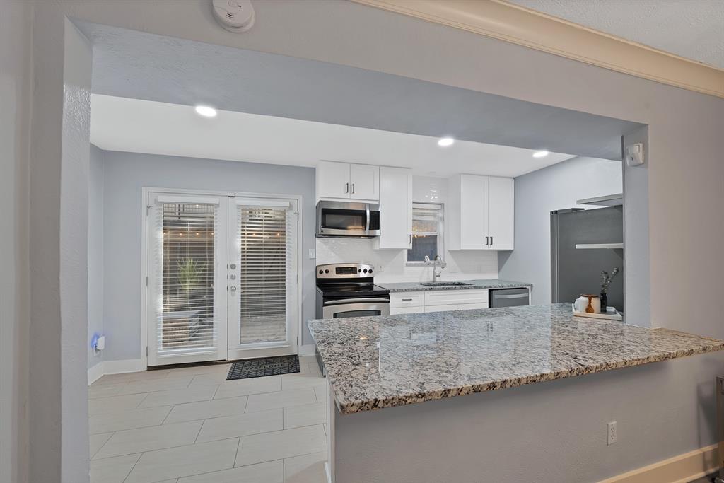 7738 Meadow Road, Unit 109 Dallas, TX 75230 - Photo 5 of 35 a kitchen with stainless steel appliances granite countertop a sink refrigerator and stove
