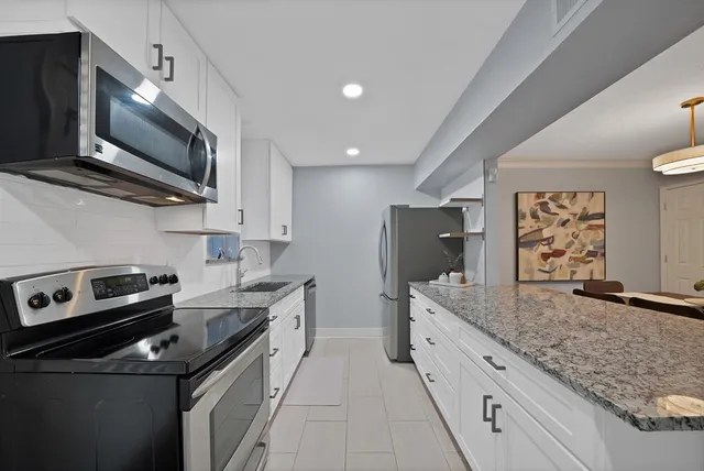 a kitchen with stainless steel appliances granite countertop a sink stove and microwave