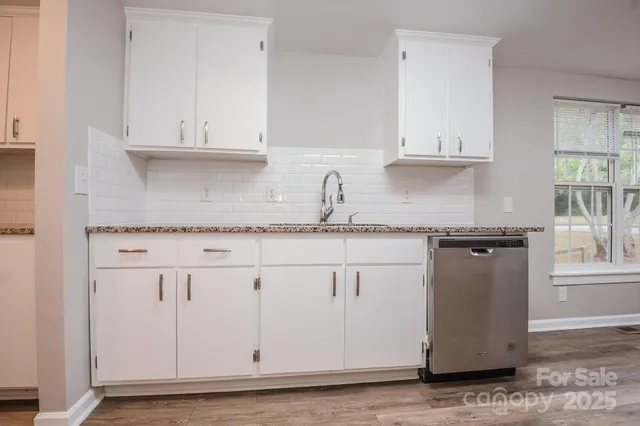a kitchen with granite countertop white cabinets and white appliances