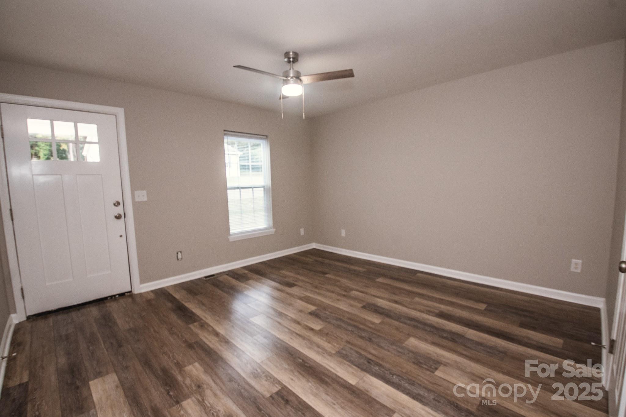 707 Summit Street Monroe, NC 28112 - Photo 6 of 23 a view of an empty room with wooden floor and a window