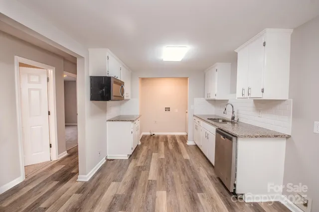a kitchen with granite countertop a sink stove and refrigerator