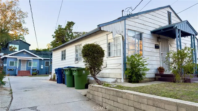 a view of a house with a yard and potted plants