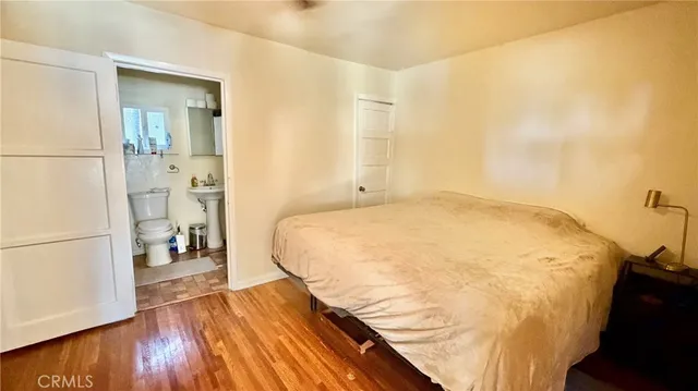 a bedroom with a bed and wooden floor
