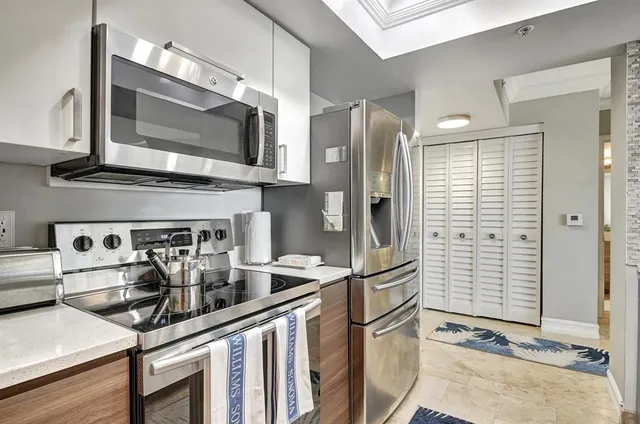 a kitchen with stainless steel appliances granite countertop a refrigerator and a stove