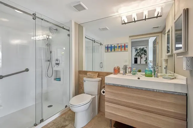 a bathroom with a sink a toilet and shower