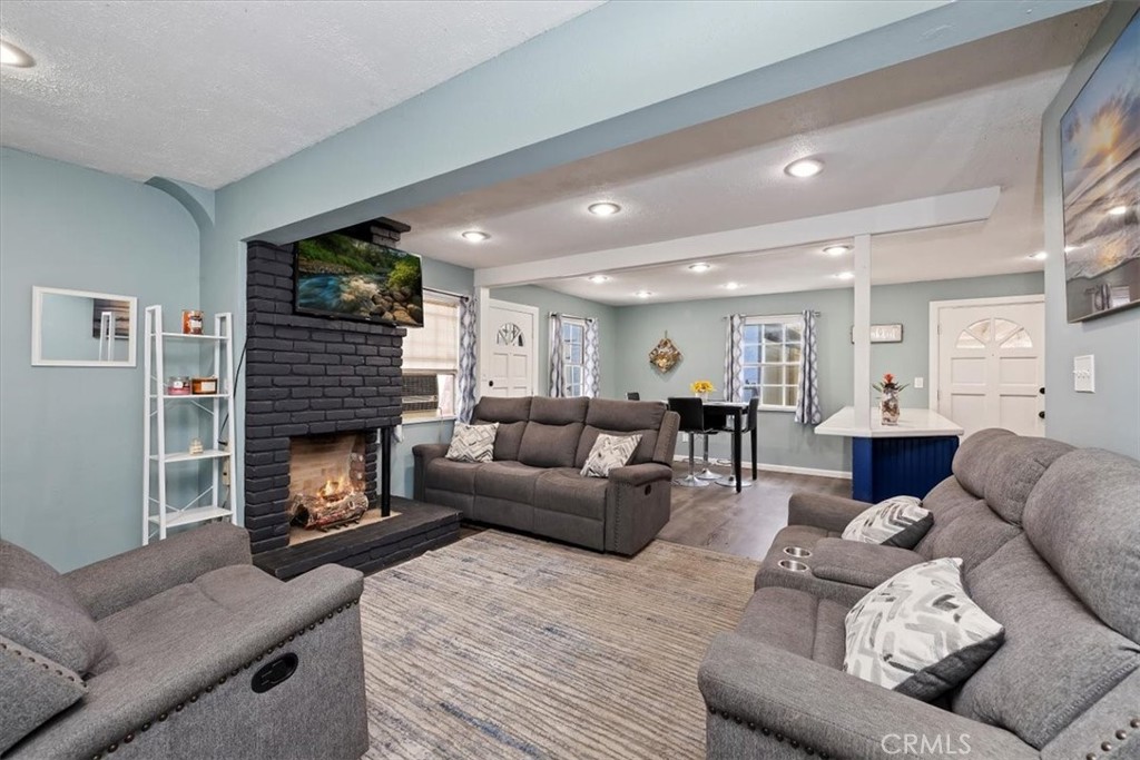 737 Edgar Avenue Beaumont, CA 92223 - Photo 9 of 43 a living room with furniture a fireplace and a flat screen tv