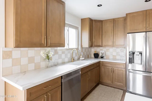 a kitchen with stainless steel appliances a sink a stove top oven a counter space and cabinets