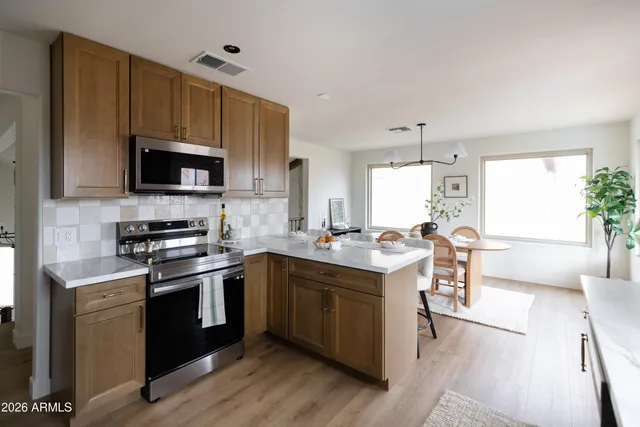 a kitchen with stainless steel appliances granite countertop a sink stove and refrigerator