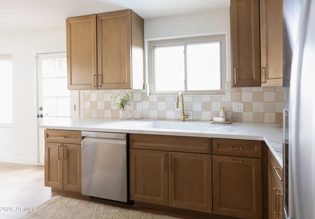 a kitchen with a sink a refrigerator and cabinets