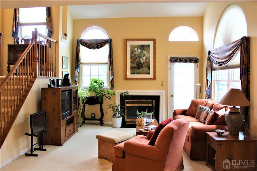 5103 Stonehedge Road, Unit 5103 Edison, NJ 08820 - Photo 6 of 25 a living room with furniture a fireplace and a floor to ceiling window