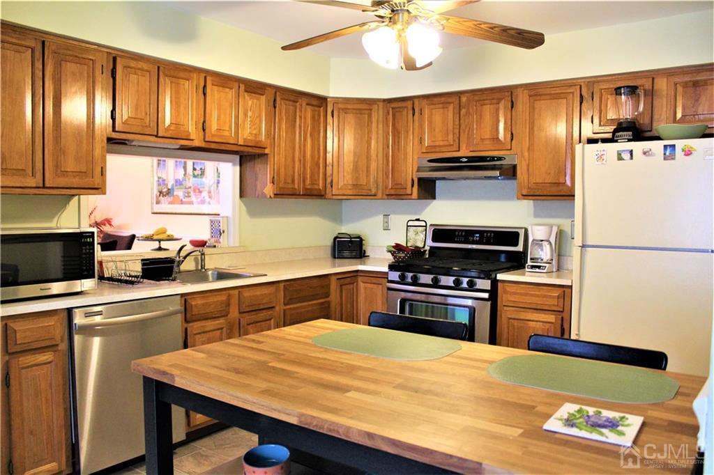 5103 Stonehedge Road, Unit 5103 Edison, NJ 08820 - Photo 9 of 25 a kitchen with stainless steel appliances granite countertop a refrigerator stove microwave and sink