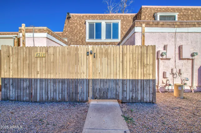 a view of a house with wooden fence