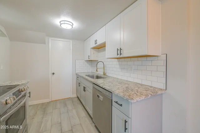 a kitchen with sink stove and cabinets