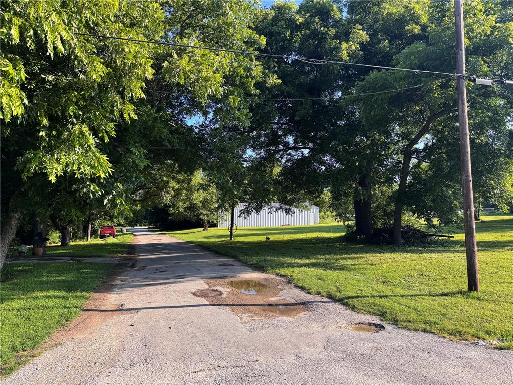 1002 6th Street Blanket, TX 76432 - Photo 15 of 16 Paved driveway extending into the property, bordered by mature trees and verdant lawns