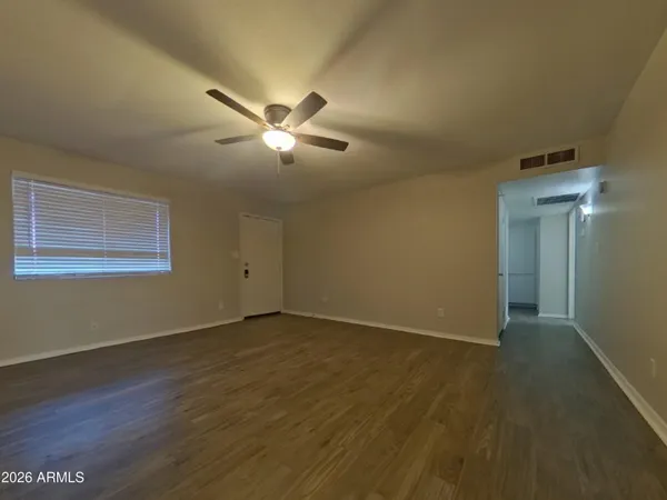 a view of empty room with wooden floor