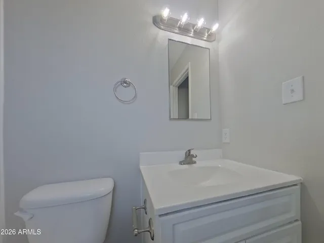 a bathroom with a sink mirror vanity and toilet