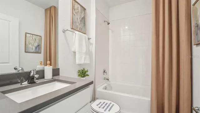 a bathroom with a granite countertop bathtub sink vanity and toilet