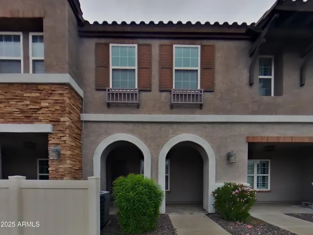 a front view of a house with plants